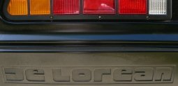 De Lorean Schriftzug in hinterer Stoßstange, Auspuffendrohr links